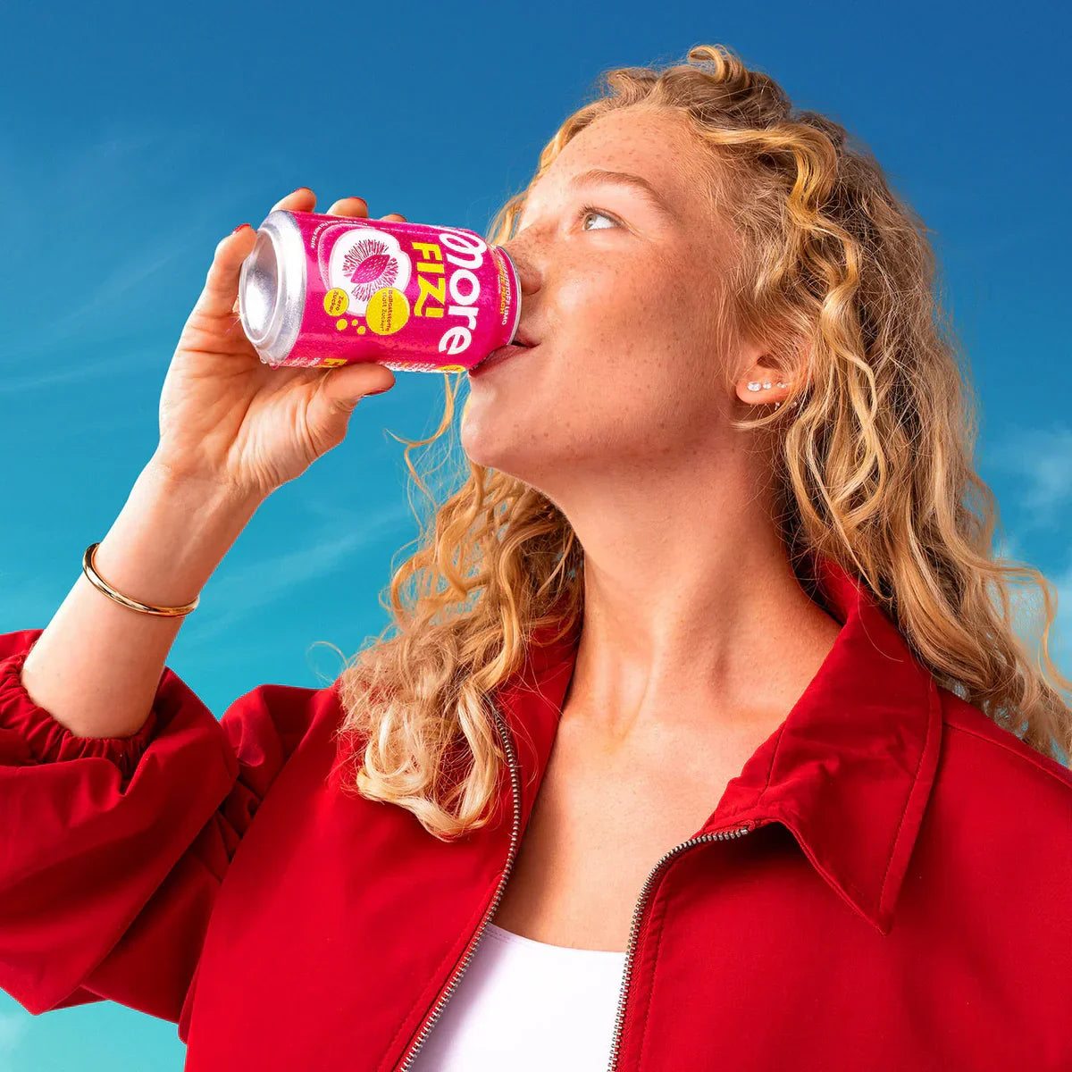 Frau trinkt More Fizi Getränk aus 330ml Dose bei blauem Himmel, Nahrungsergänzung, Fitness